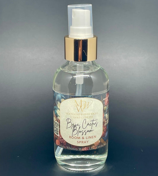 Clear spray bottle with gold cap labeled 'Baja Cactus Blossom' on a dark background from Moonlight Whimsy Wicks
