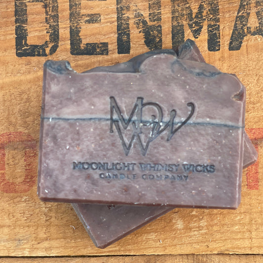 Handmade Cocoa Butter & Coconut soap bar by Moonlight Whimsy Wicks, featuring a layered design in warm earthy tones with the MWW logo stamped on top, set on a rustic wooden background.