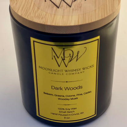 Close up shot of a Moonlight Whimsy Wicks 8 oz Candle in a black vessel with a gold label.