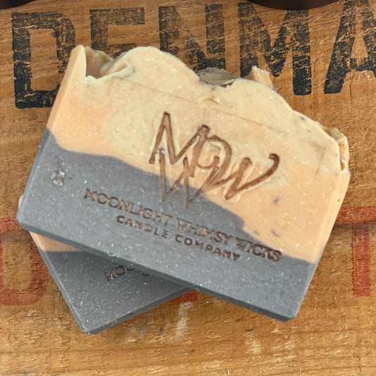 Handmade Honey Spiced Pear soap bar by Moonlight Whimsy Wicks, featuring warm tan and charcoal layers with the MWW logo stamped on top, displayed on a rustic wooden background.