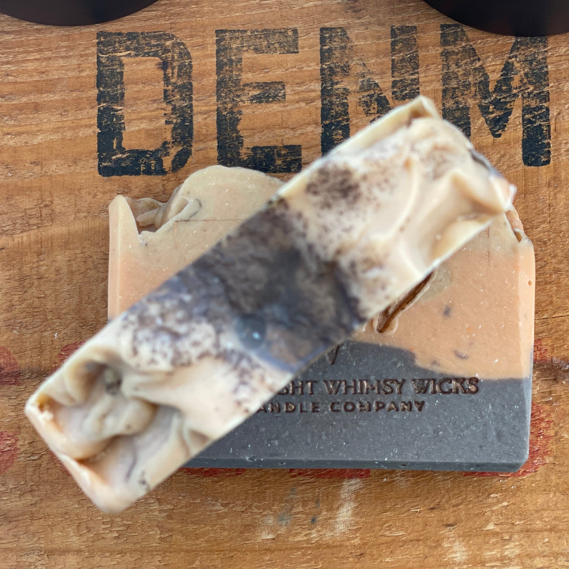 Handmade Honey Spiced Pear soap bar by Moonlight Whimsy Wicks, featuring warm tan and charcoal layers with the MWW logo stamped on top, displayed on a rustic wooden background.