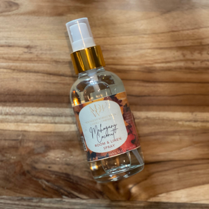 Mahogany Coconut Room and linen spray by Moonlight Whimsy Wicks bottle on a wooden surface