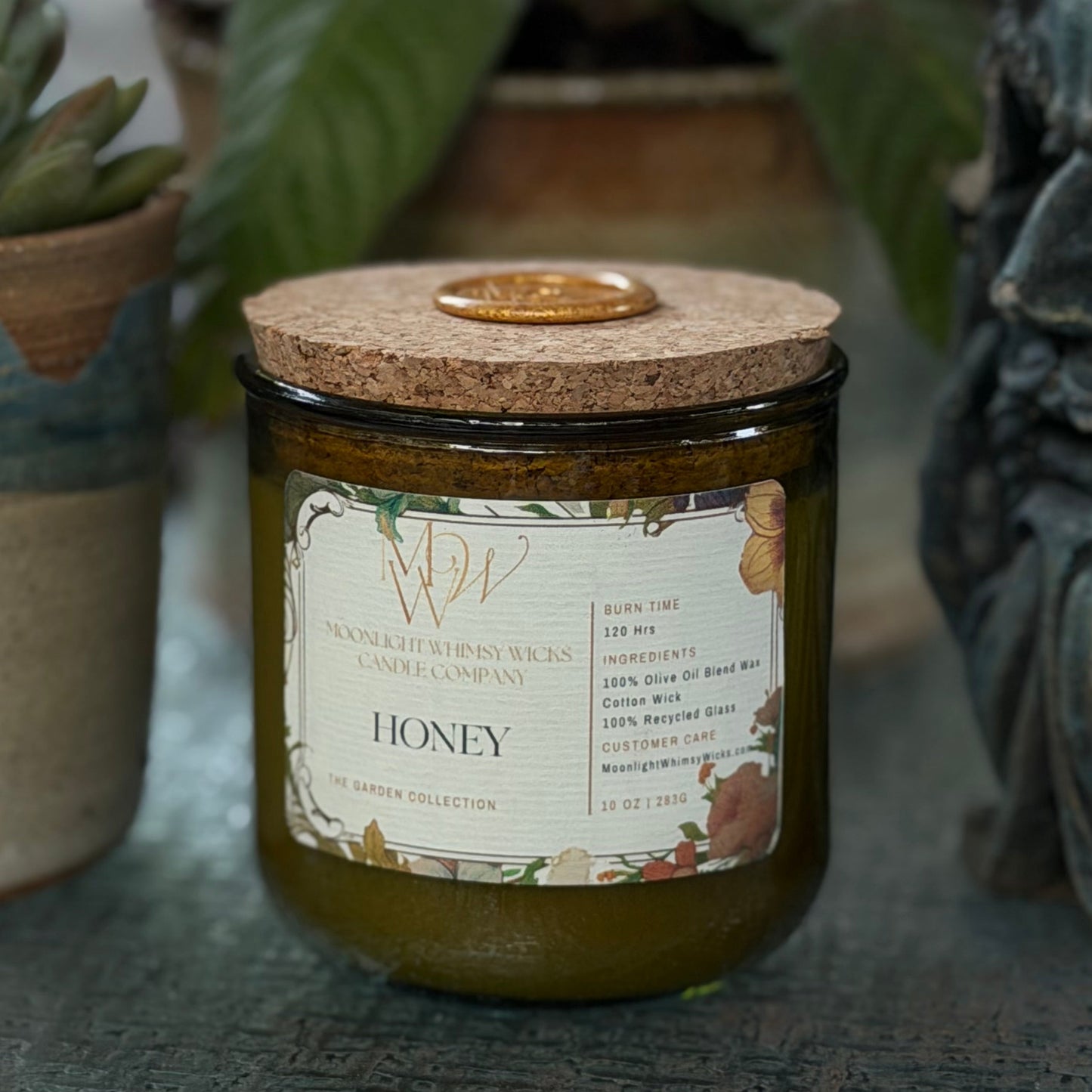 Candle labeled 'Honey' with decorative elements on a surface