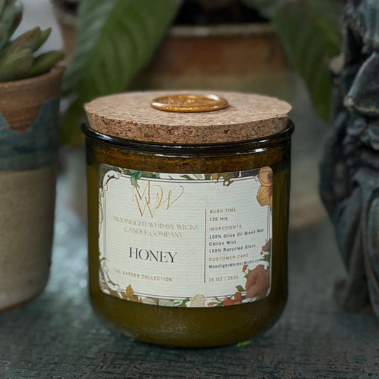 Candle labeled 'Honey' with decorative elements on a surface