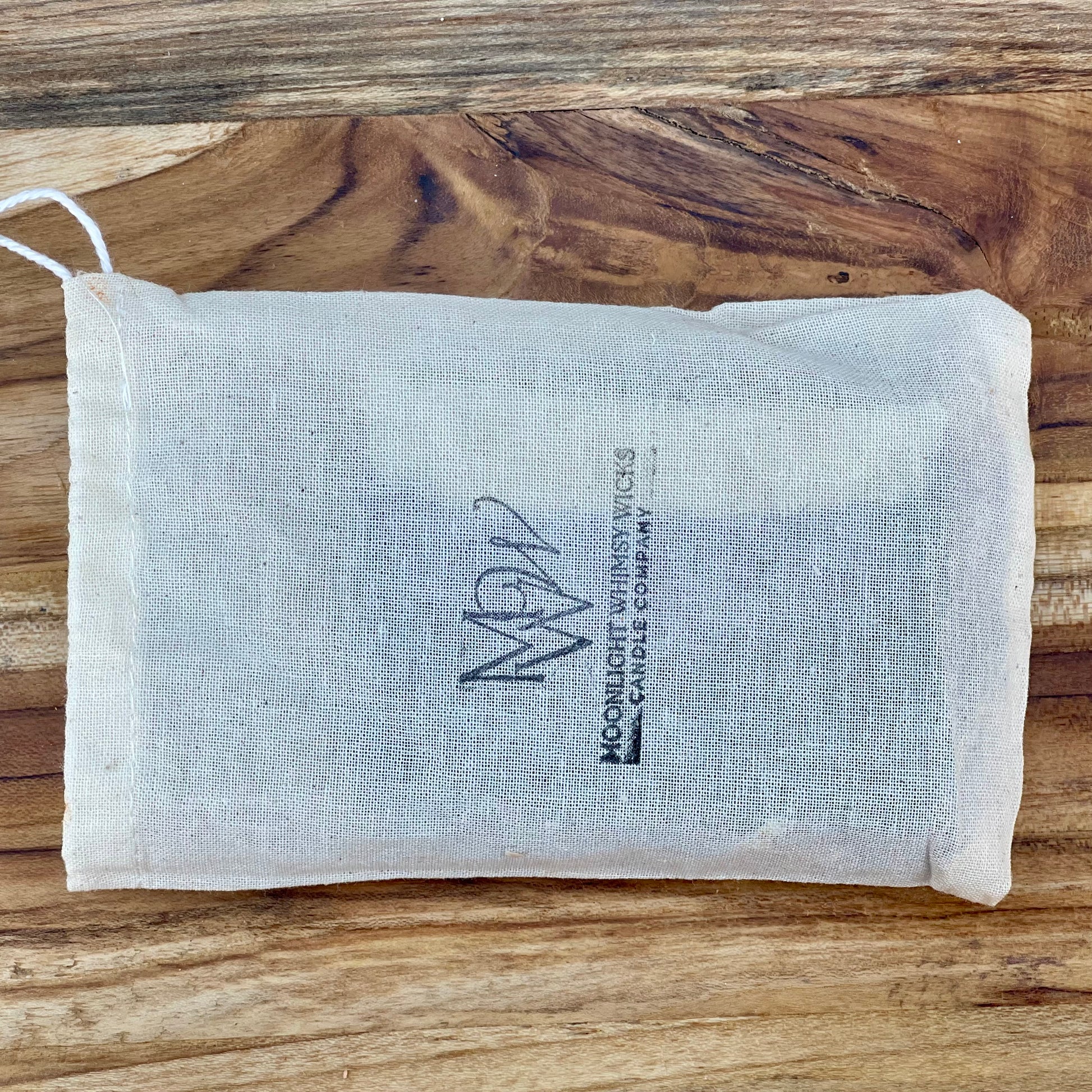 Eco-friendly muslin gift bag with Moonlight Whimsy Wicks logo, containing handmade cold processed soap. Sustainable packaging for natural soap bars, ideal for gifting and luxury skincare routines.
