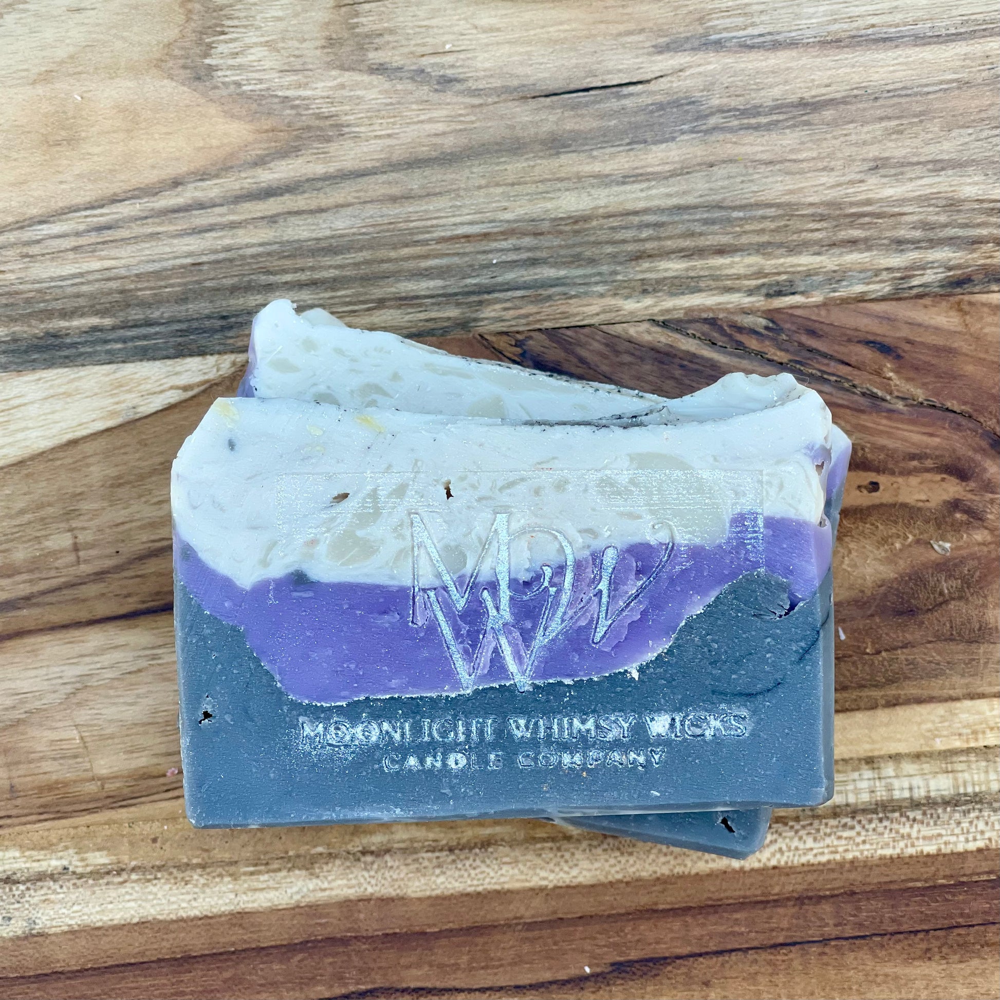Moonlight Whimsy Wicks artisan soap bar with dramatic layers of charcoal black, lavender purple, and creamy white. Handmade cold processed soap.