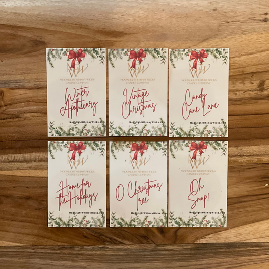 Set of six Christmas-themed cards with red bows on a wooden surface