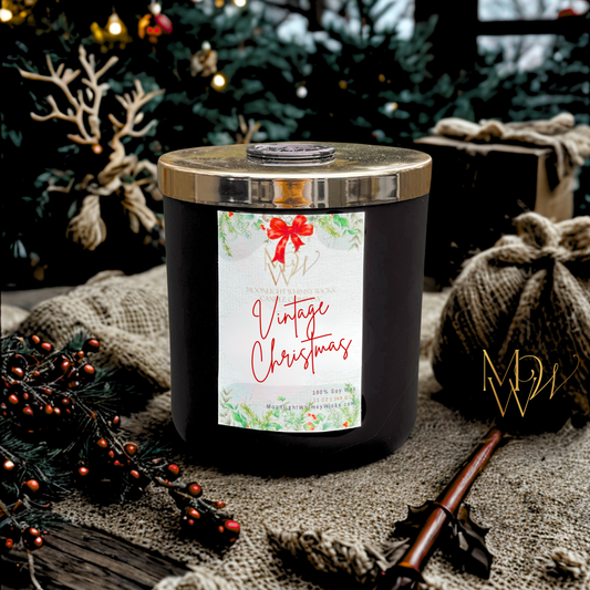 Hand-poured Vintage Christmas soy candle in matte black jar with gold lid and wax seal, surrounded by rustic holiday decor, red berries, burlap, and Christmas tree. Artisan Christmas candle by Moonlight Whimsy Wicks for cozy home rituals and nostalgic winter ambiance.