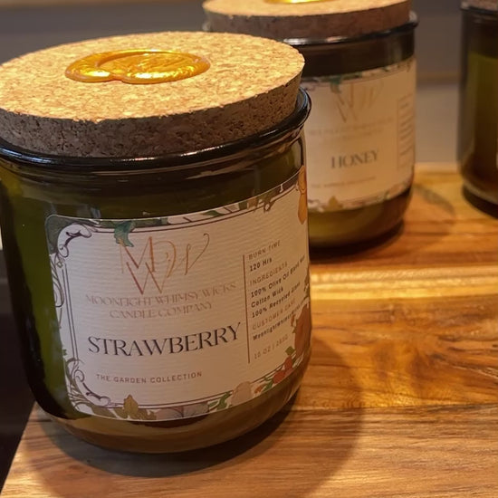 Video showcasing the Heirloom Tomato, Honey, Thyme, Lemongrass, Peaches and Strawberry Candles from Moonlight Whimsy Wicks' Garden Collection. Features the eco-luxury candle in a heritage green glass vessel with creamy olive oil wax and a cork lid sealed in gold wax, surrounded by garden-fresh tomatoes and herbs. Ideal for lovers of sustainable, botanical-inspired home fragrance.