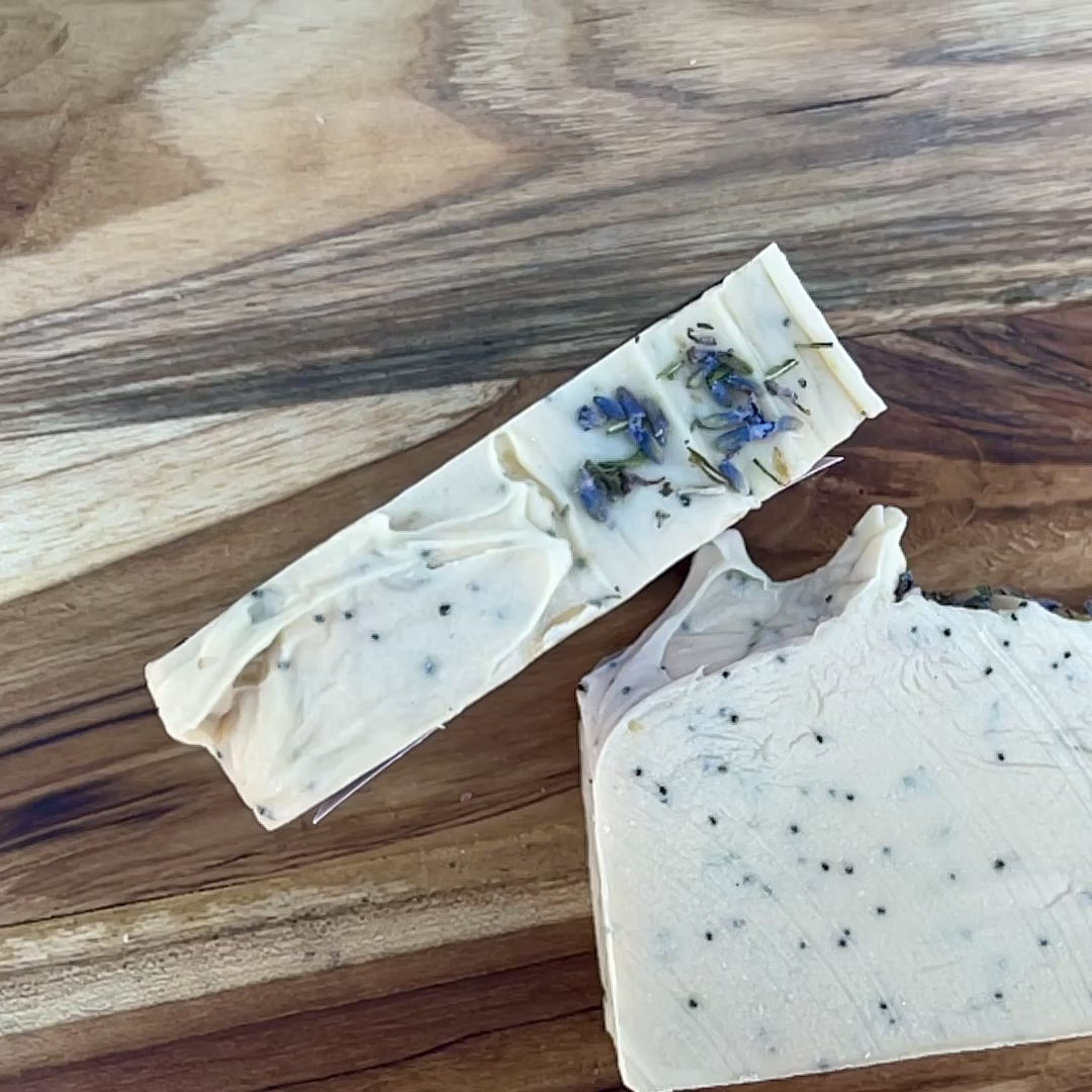 Close up video of handmade cold processed exfoliating soap bar with natural poppy seeds, crafted by Moonlight Whimsy Wicks. Soap for gentle exfoliation and moisturizing skincare, made in small batches for sensitive and dry skin.