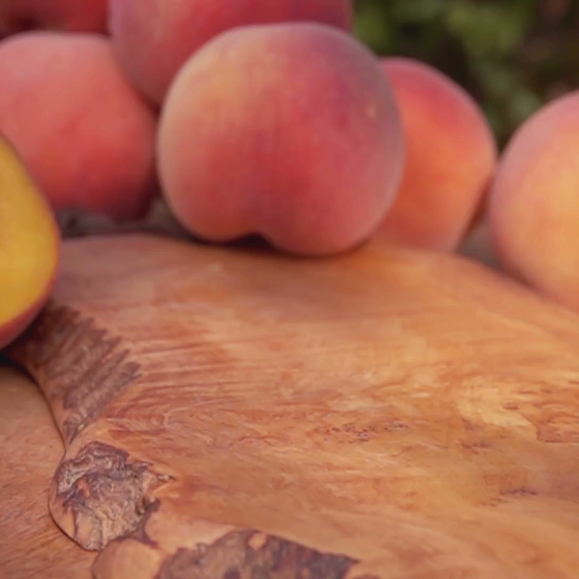 A soft, sunlit video showcasing the Peaches Candle from Moonlight Whimsy Wicks. The candle is styled in a green recycled glass jar with a cork lid and floral label, set against a warm, rustic background. Visuals evoke the scent of ripe peach nectar, green leaves, and summer orchard memories—part of the Garden Collection.